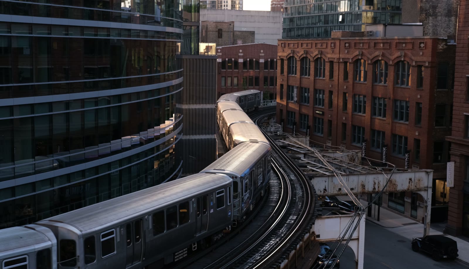 Elevated train curving past brick and glass buildings in Chicago